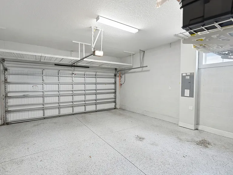 Large 2-car garage with built in storage on wall and over garage door