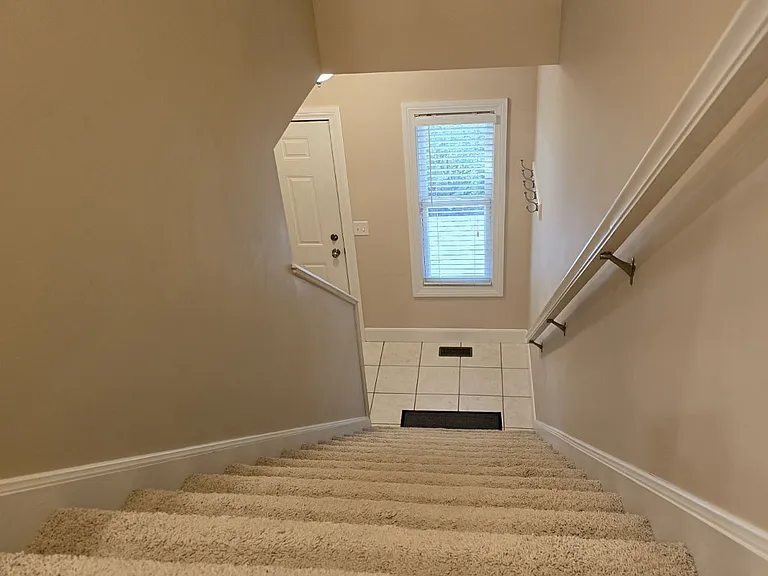 Stairway shows own private entry to front of house. Also has door to attached garage (not shown here).