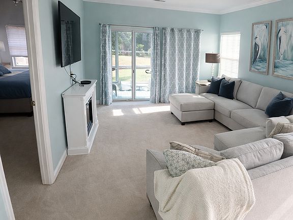 Living room with EZ breeze patio behind it with view of golf course