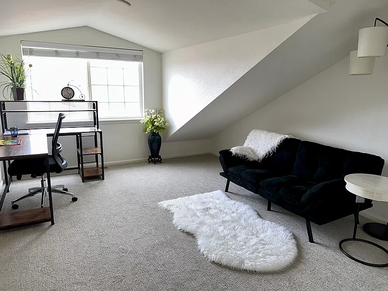 Loft with futon, desk, chair and full bathroom.