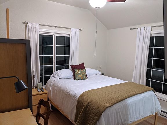 Queen-sized bed and small wardrobe; desk