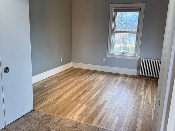 Bright living room with newly refinished hardwood floors, fresh neutral tones, and lots of natural light.