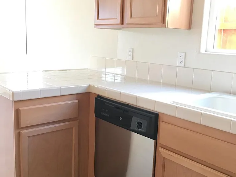 Kitchen with very clean countertop, electrical outlets for your kitchen appliances, and Stainless steel dishwasher. Reverse osmosis under the sink has been installed.