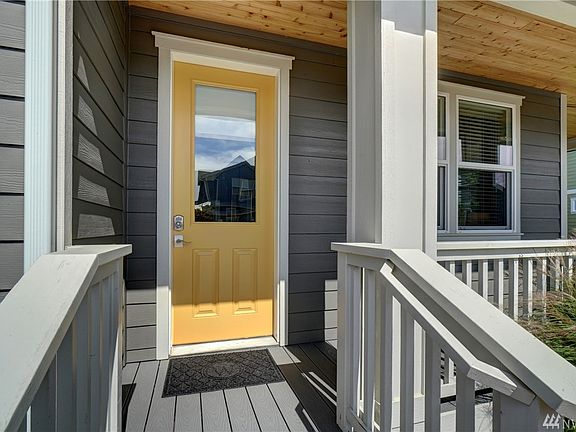 The covered front porch has a custom door with a pop of color to welcome your guests. 
