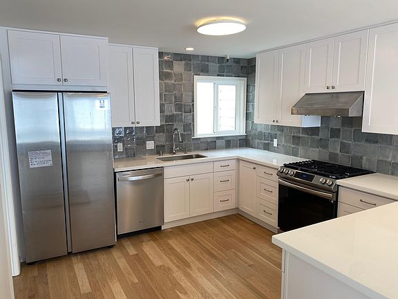 Spanish ceramic tile backsplash, quartz countertops and new appliances