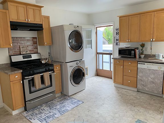Kitchen equipped with washer, dryer, stove, dishwasher, and refrigerator