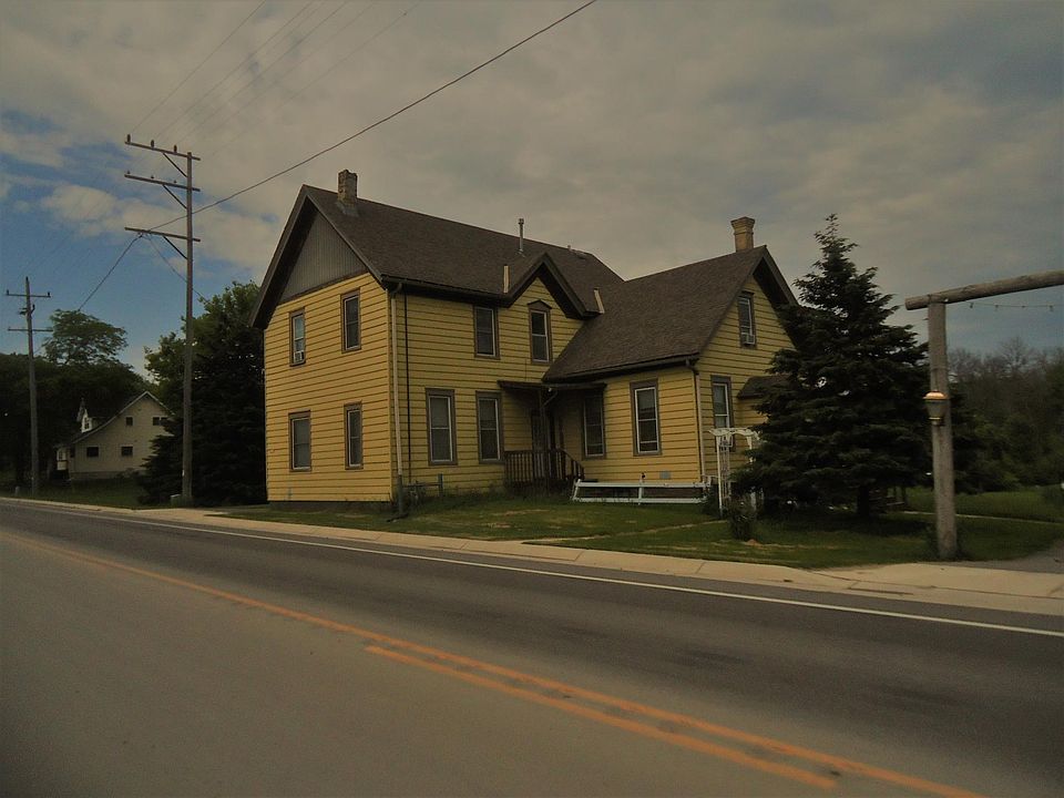 Has separate entry--porch showing on this picture. Wrap around driveway. Large detached garage.