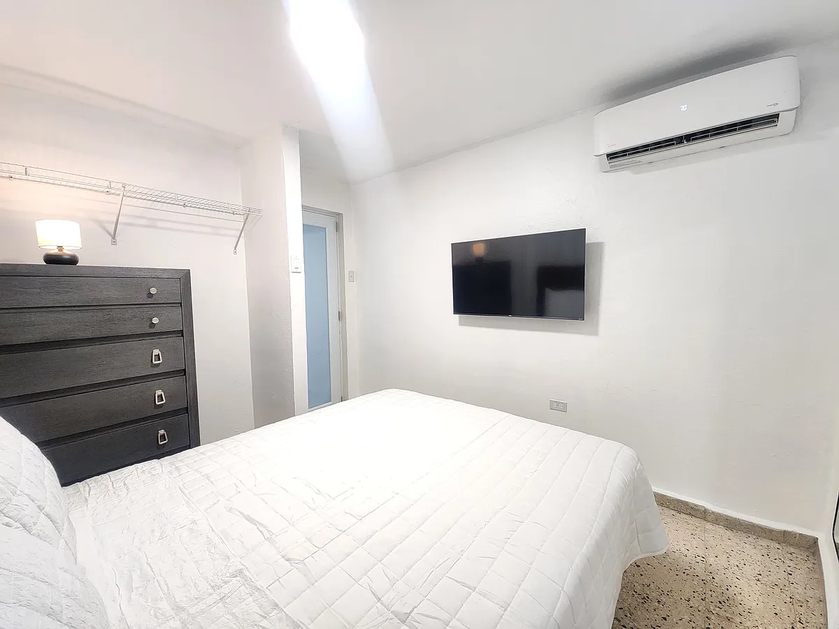 Master bedroom with queen size bed, 43" TV and mini split ac unit. - Calle Ave
