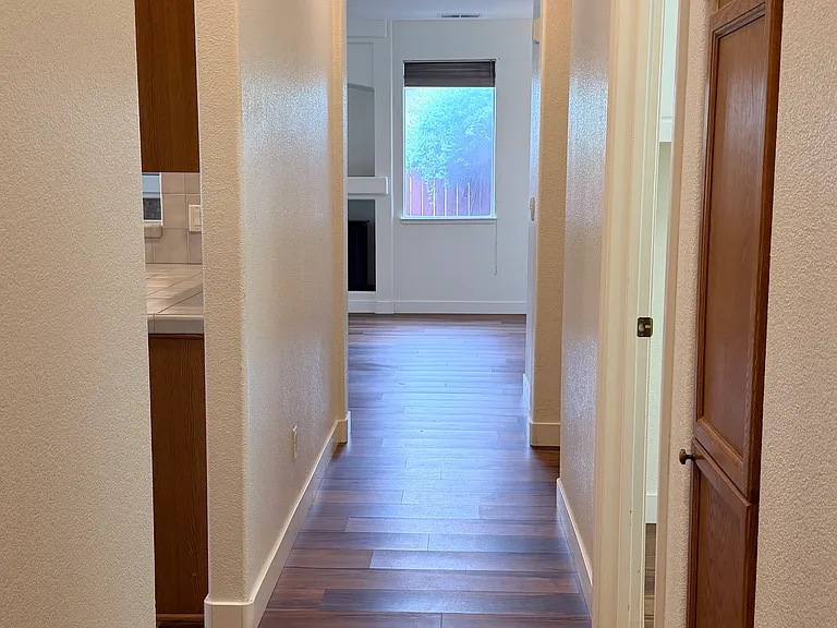 Hallway from master looking past kitchen on left and laundry on right