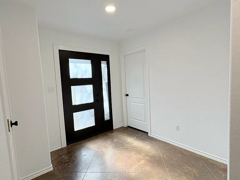 The home features a welcoming entrance foyer that opens into the kitchen and main living area. The left is the master bed and bath and to the right s large coat closet.