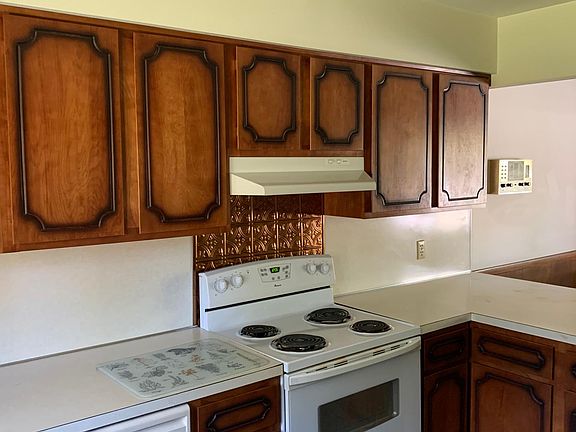 Part of kitchen with electric range and dishwasher included.