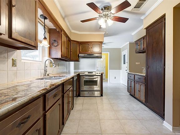 12x10 Kitchen - A galley kitchen with updated appliances and granite counter. The breakfast room is in the background.