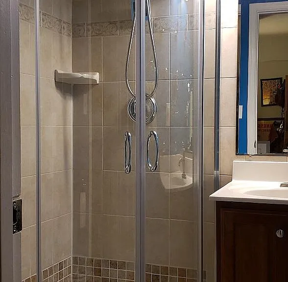 New deluxe shower installed 2021 with sliding curved doors, large rain showerhead plus handheld on hose with massage settings. Water filter to reduce calcification. Tile treated to inhibit mold growth. Corner shelf.