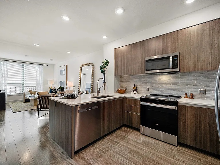 Open kitchen with quartz counters and ample modern cabinetry