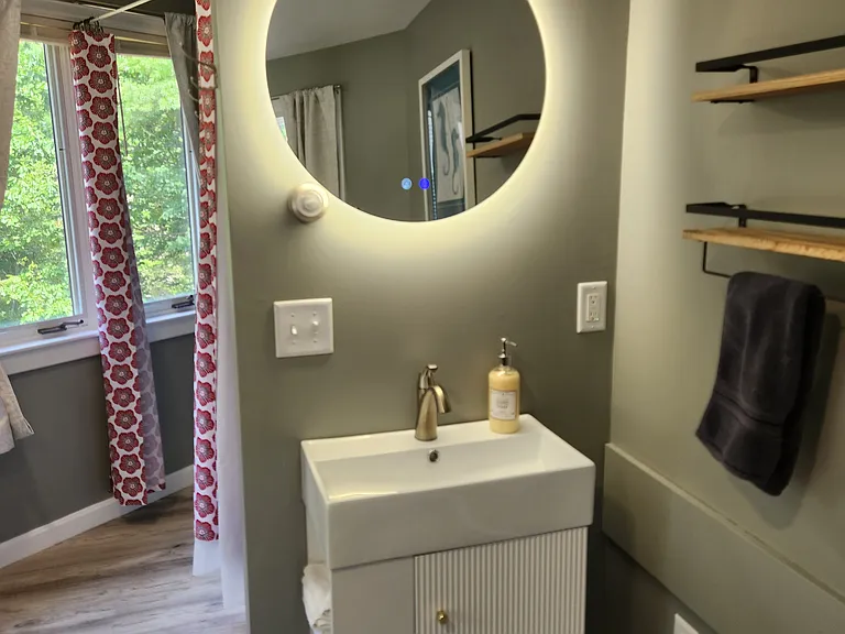 Bedroom 3 with queen bed on second floor, separate entrance, mini-fridge, mircowave, smart TV, fold away table and chairs, shower stall, bathroom sink, toilet, and views of backyard.