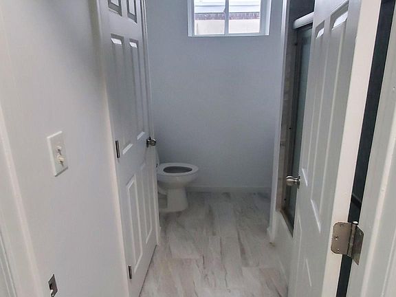 Bathroom with a marble motif, large storage closet, rain style shower head and extra light with heating capability