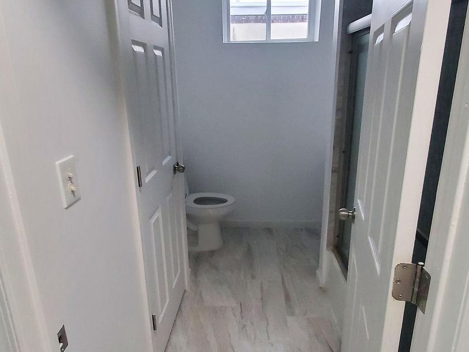 Bathroom with a marble motif, large storage closet, rain style shower head and extra light with heating capability