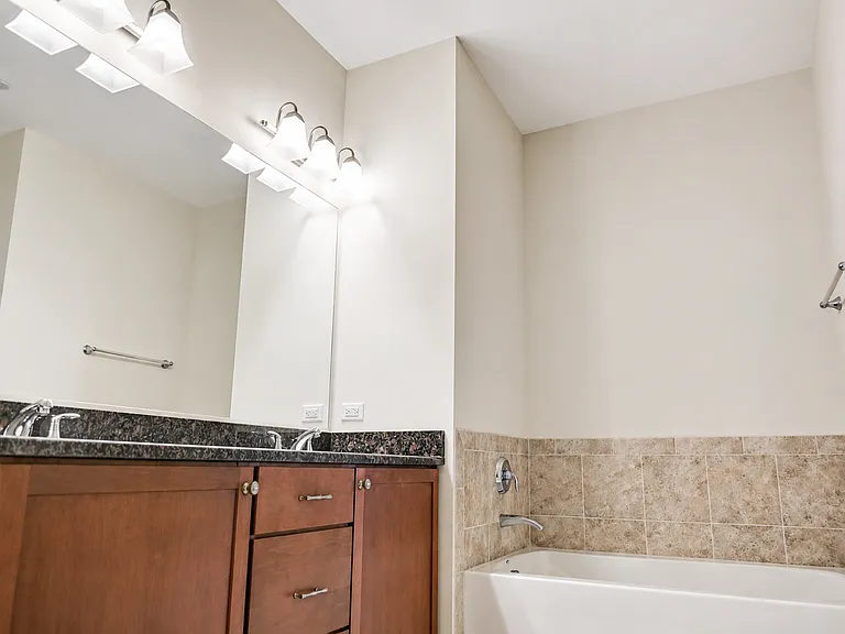 Spacious primary bathroom featuring a large soaking tub and a glass-enclosed shower located across from the toilet.