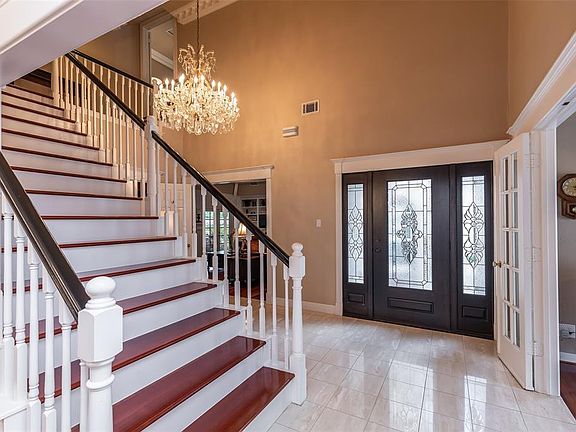 Upon entry you are greeted by a grand 2-story foyer with marble floors, custom chandelier and elegant hardwood stairs.