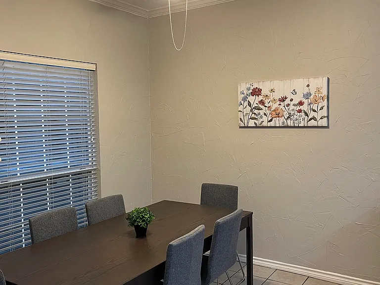 Dinette - furnished with table and six chairs, plus wall decor. Shared space.