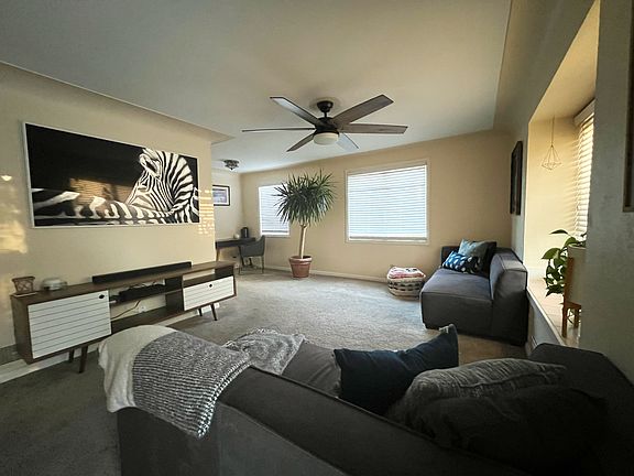 L-Shaped living room with large front sunny window.