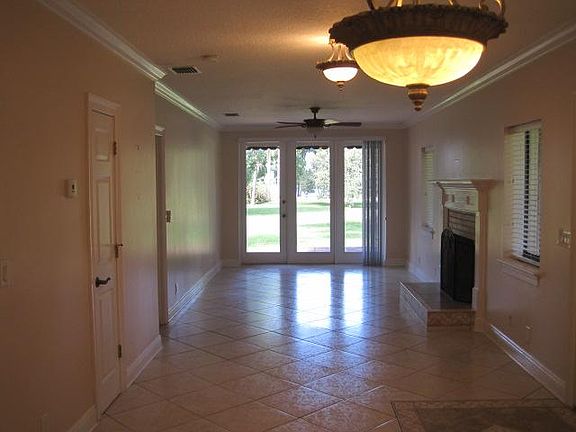 Dining and living room area with fireplace. View of the lake and access to patio and ceiling fans in all rooms.