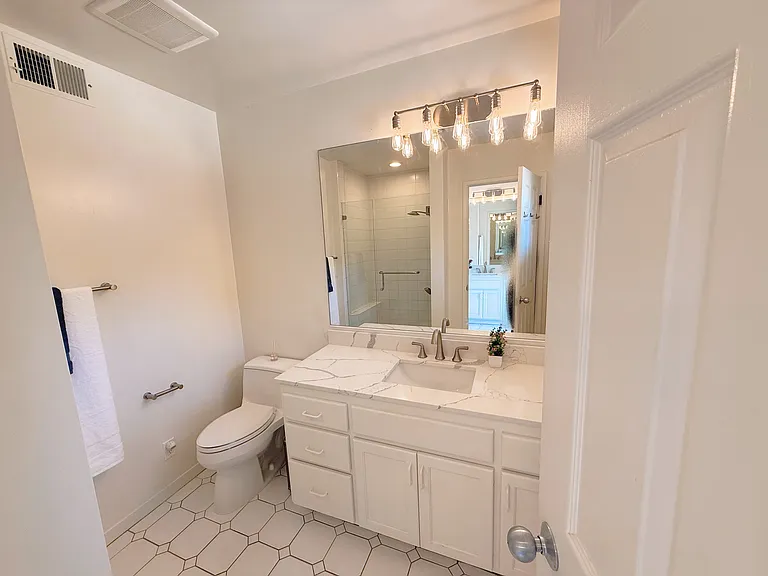 Primary bathroom with new countertop, mirror and lighting features