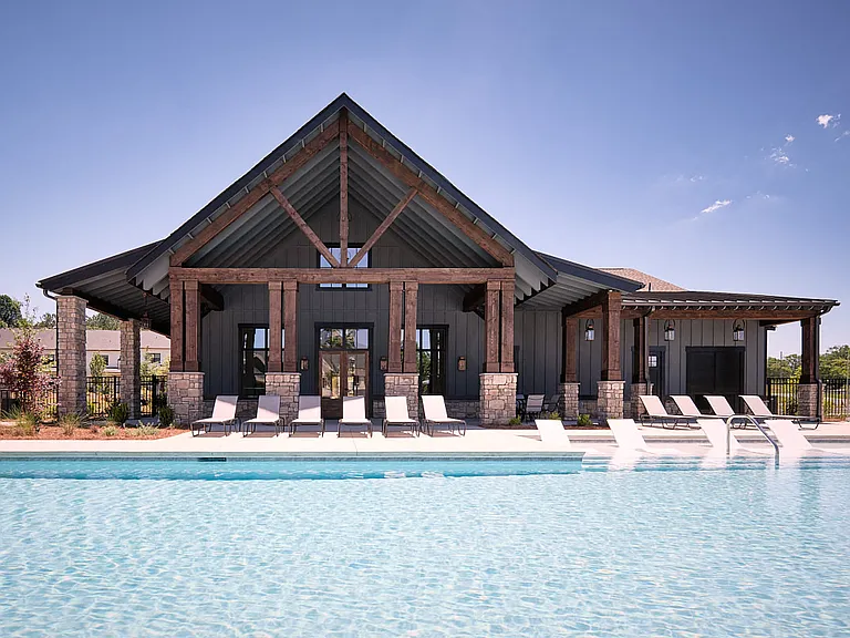 Resort-style pool with ample seating, lounge chairs and umbrellas.
