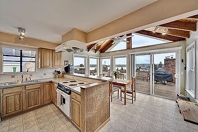 Spacious kitchen and breakfast nook with vaulted wood-paneled ceiling. 