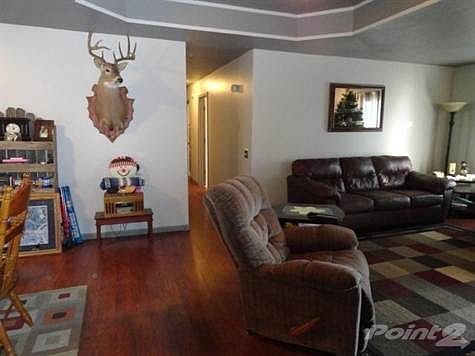 Living room with laminate flooring, tray ceiling.