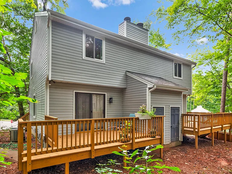 Back yard with a large deck and steps down to the yard. There is also a private outside storage room for extra storage space!