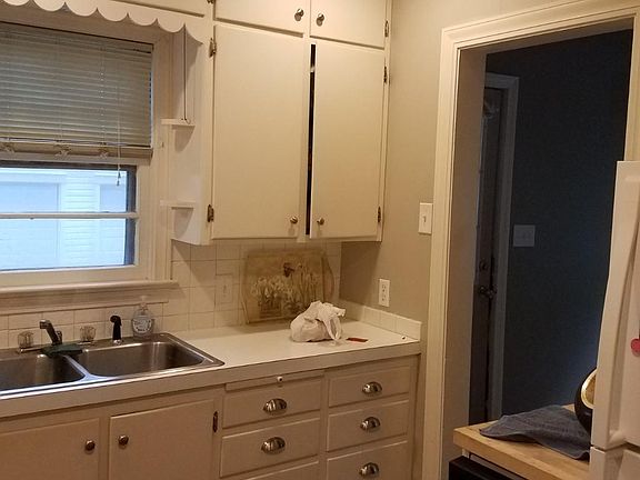 Kitchen also has vinyl tile flooring and a butcher block counter.