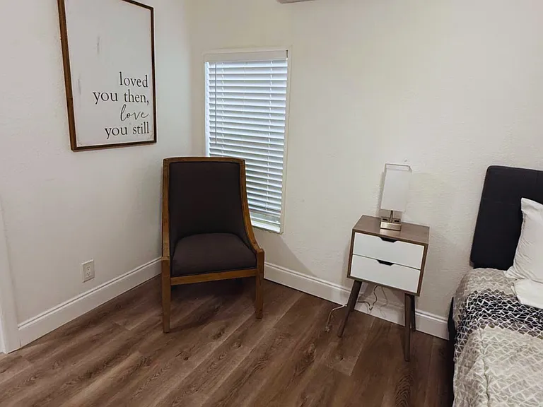Comfortable bedroom with AC and a cozy chair for reading or relaxing.
