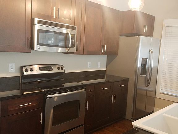 Granite countertop, farmhouse style sink, stainless appliances, pantry