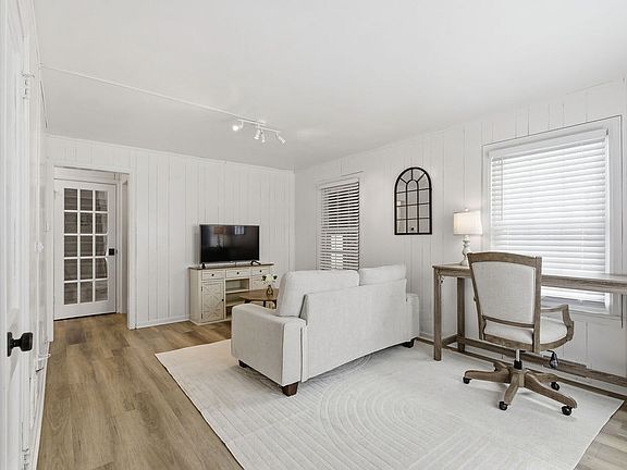 The living area offers a space for watching TV and a desk that creates a functional workspace for everyday needs.