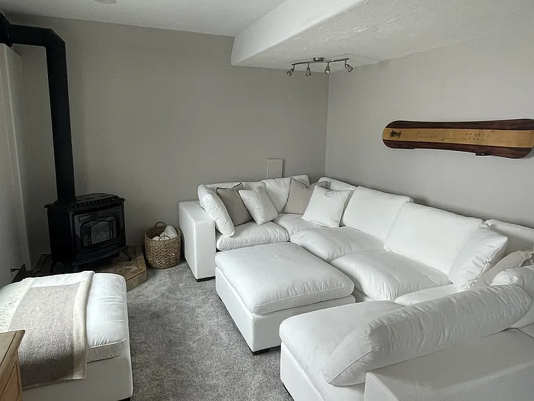 Living room (couch not included) with potbelly stove that complements central heating.