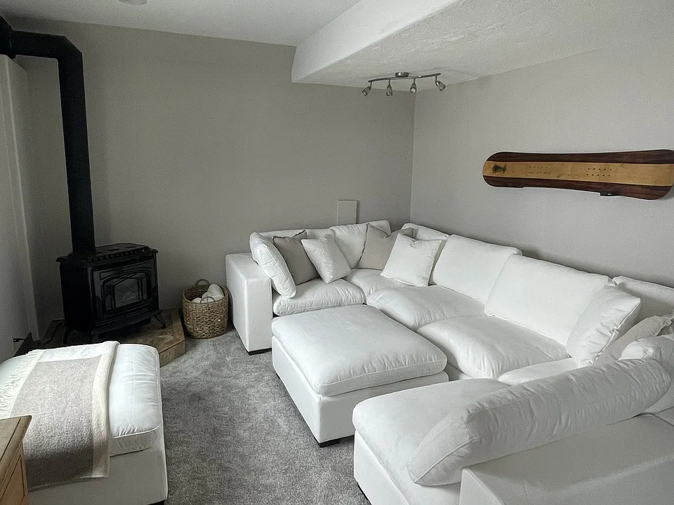 Living room (couch not included) with potbelly stove that complements central heating.