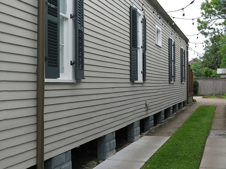 The side of our home has a new driveway, operable shutters and string lights!