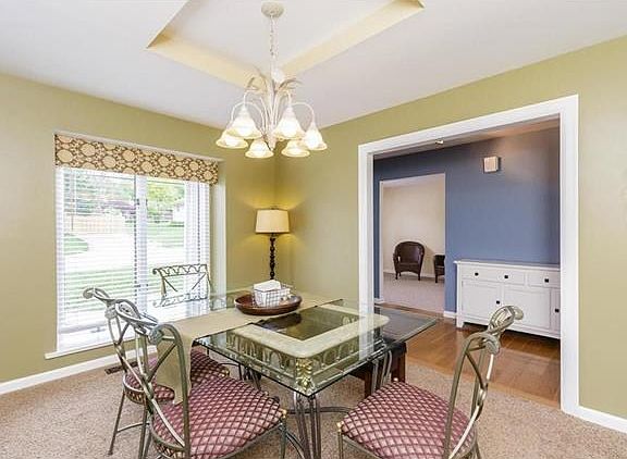 Separate Dining Room with tray ceiling, large picture window and newer carpeting.