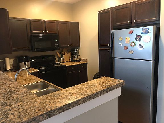 Nice dark brown cabinets with refrigerator, microwave, oven, and dishwasher (left of the sink).
