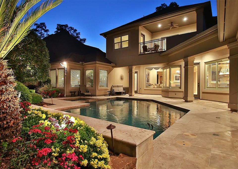 STUNNING HOME WITH COVERED PATIOS - Night time is so peaceful in this back yard oasis with beautiful pool and spa, two covered patios and custom pool with waterfall.