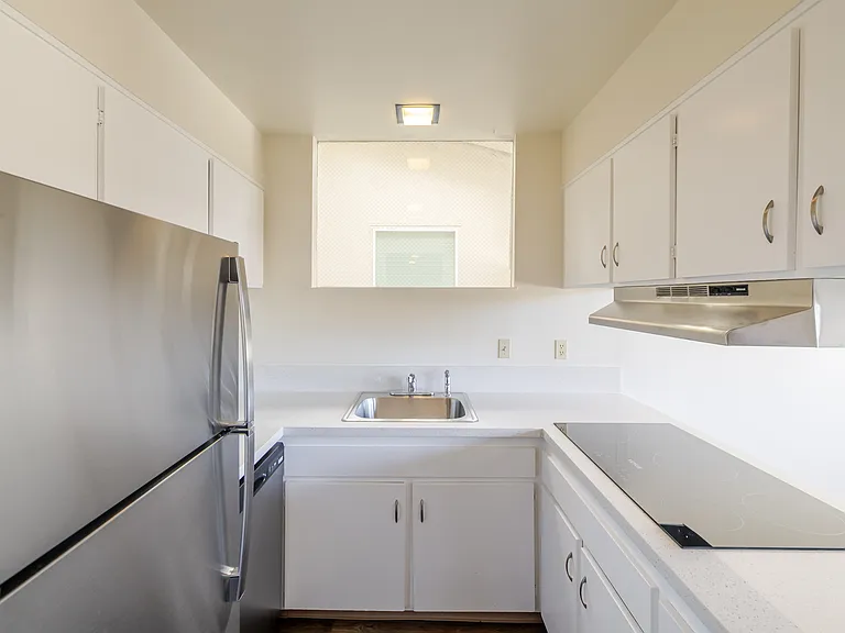 Efficient galley kitchen with ample cabinetry and stainless steel appliances.