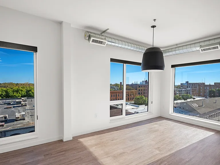 Bright and airy apartment room with large windows offering stunning city views, sleek modern design, and abundant natural light. Bright and airy apartment room with large windows offering stunning city views, sleek modern design, and abundant natural ligh
