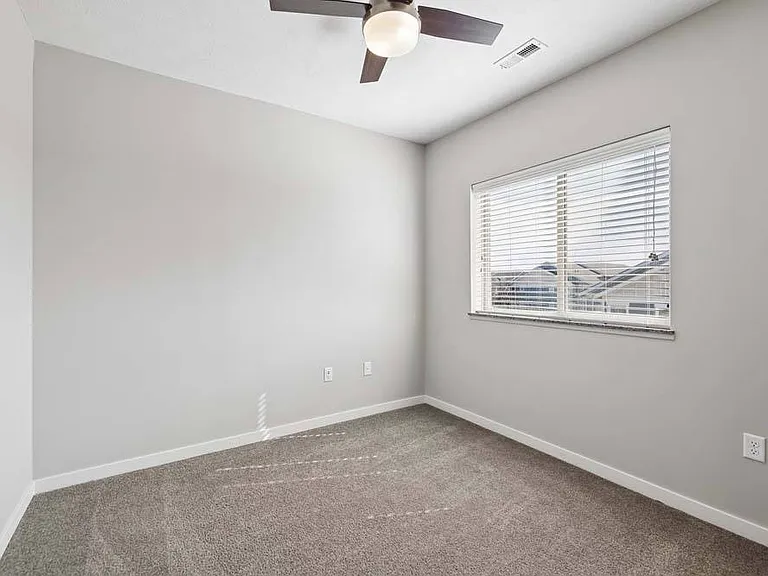Soft carpeting, abundant natural light, and a versatile layout make this bedroom an inviting space to relax and recharge.