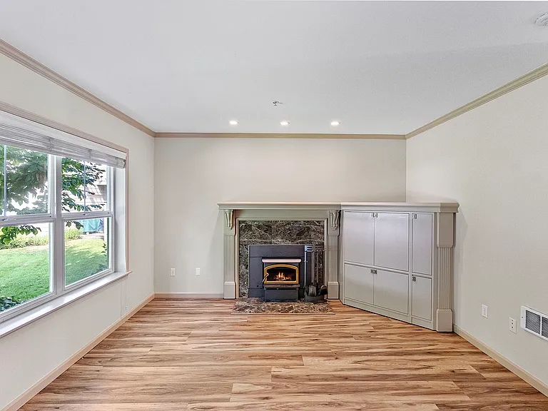 Cozy wood-burning fireplace and built-in storage in downstairs living area.