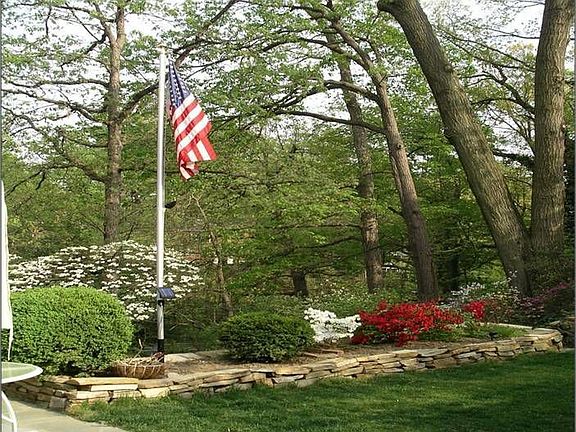 Private Backyard with Lush Perennials and Large Flat Stone-Fenced Yard Area