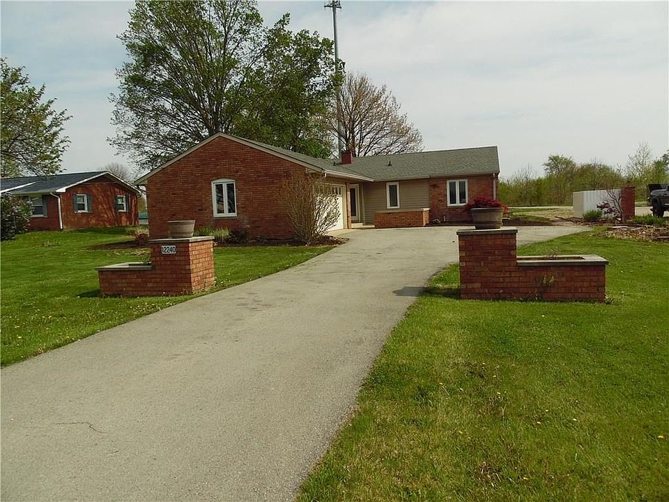 Brick pillars/planters and asphalt driveway provide a warm welcome!