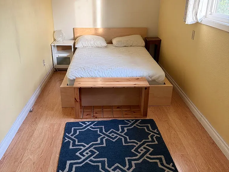 Long narrow bedroom (with built-in white cupboards for storage and closet not pictured here).