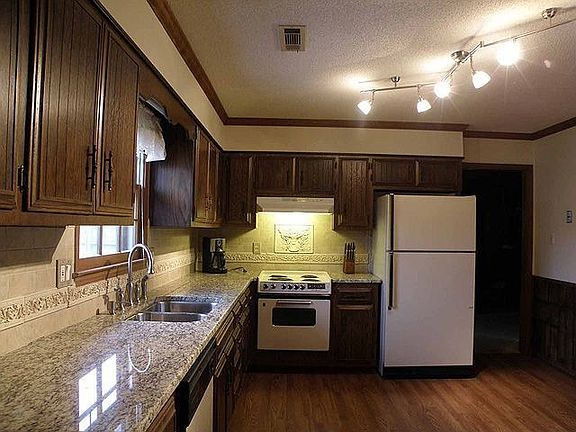 Kitchen has wood floor, granite countertops, new fixtures and lights.