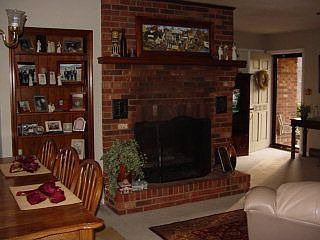 The living room has a large brick fireplace with gas logs.